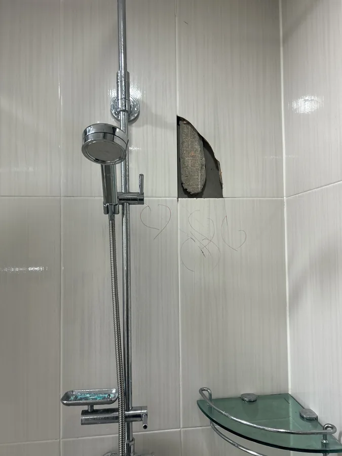 화장실 부분 타일리폼 전, 샤워 공간 모서리에 생긴 타일 구멍