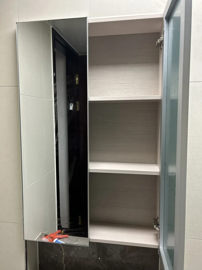 낡은 욕실 수납장교체 후, 새로운 유리문이 설치된 수납장